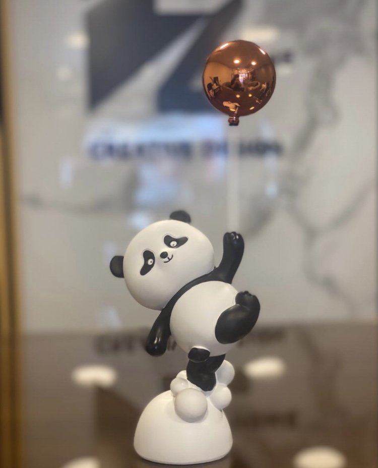 Panda figurine holding a balloon
