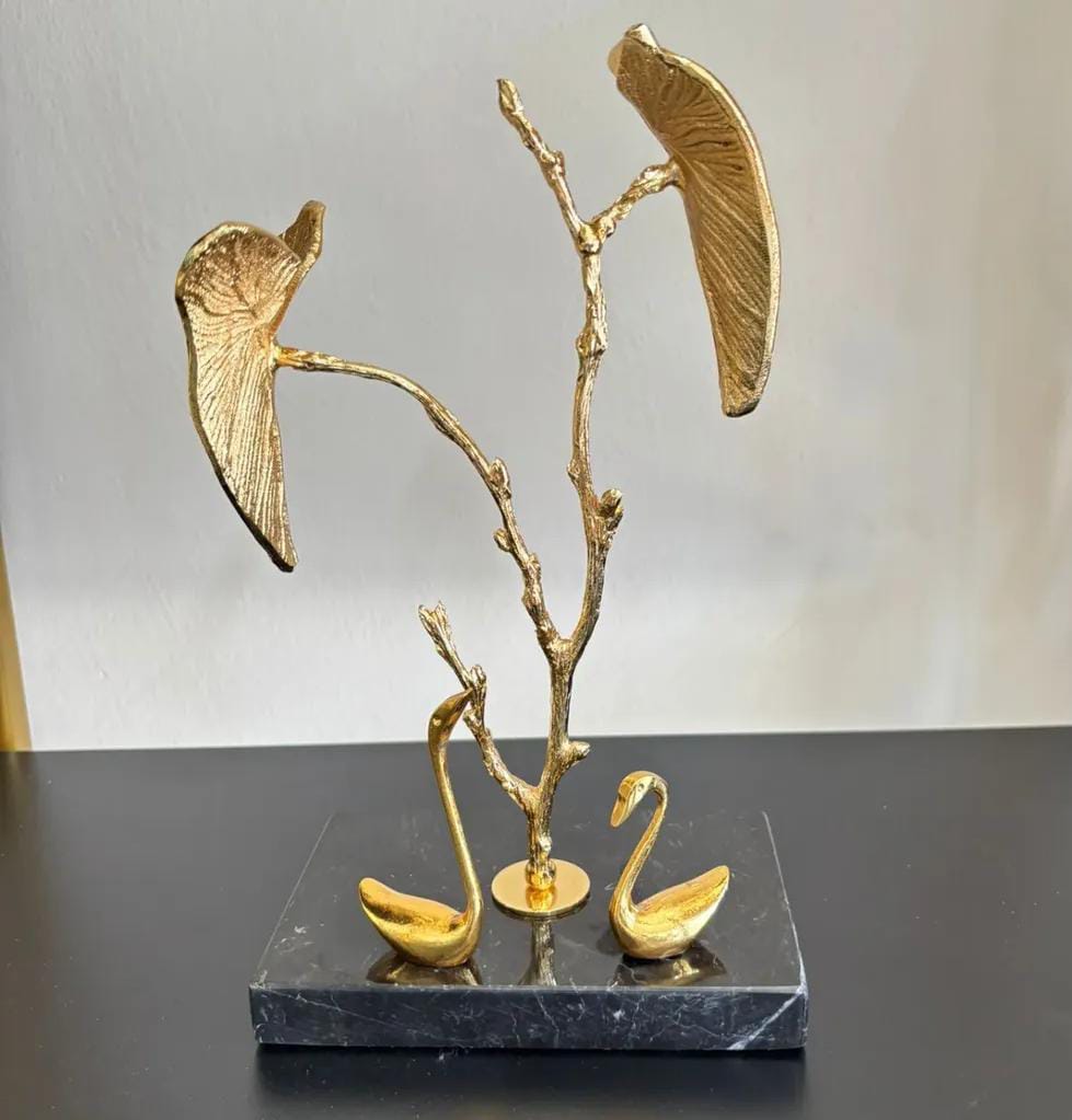 2 decorative ducks on a black marble base with autumn leaves