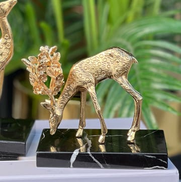 Golden deer on a base marble black