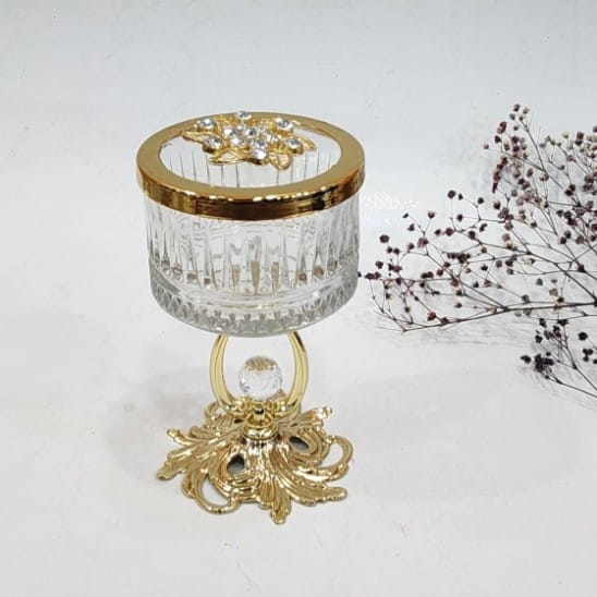 Decorative glass sugar bowl or candy dish featuring a gold-toned stand and lid
