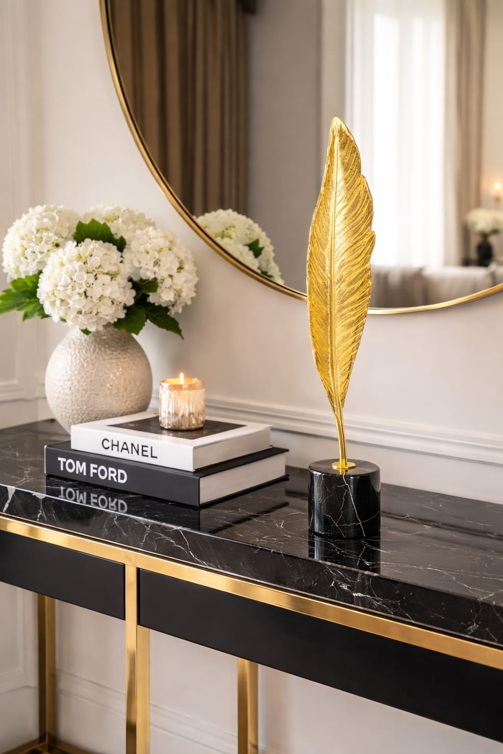 A gold-finished feather design mounted on a black marble base