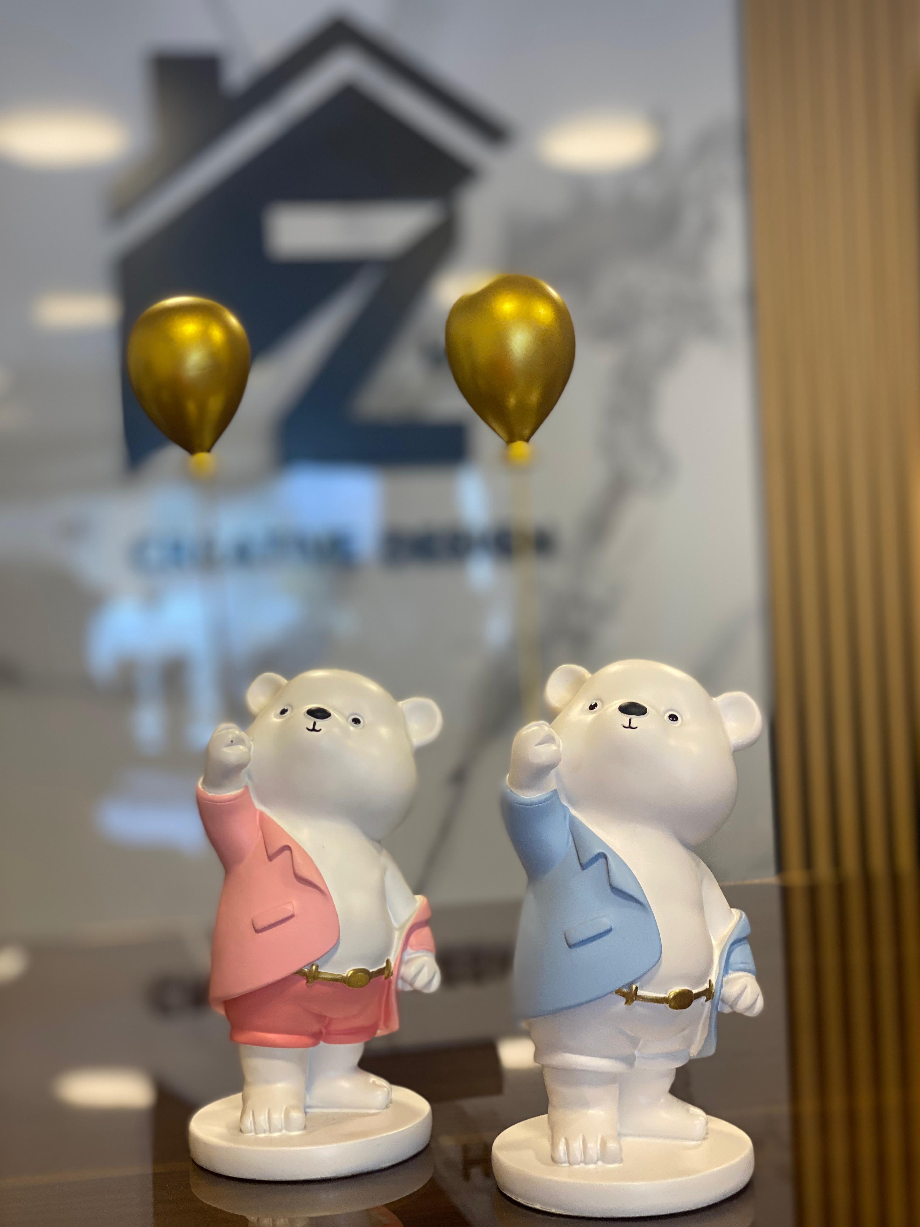 Bear statues with golden balloons