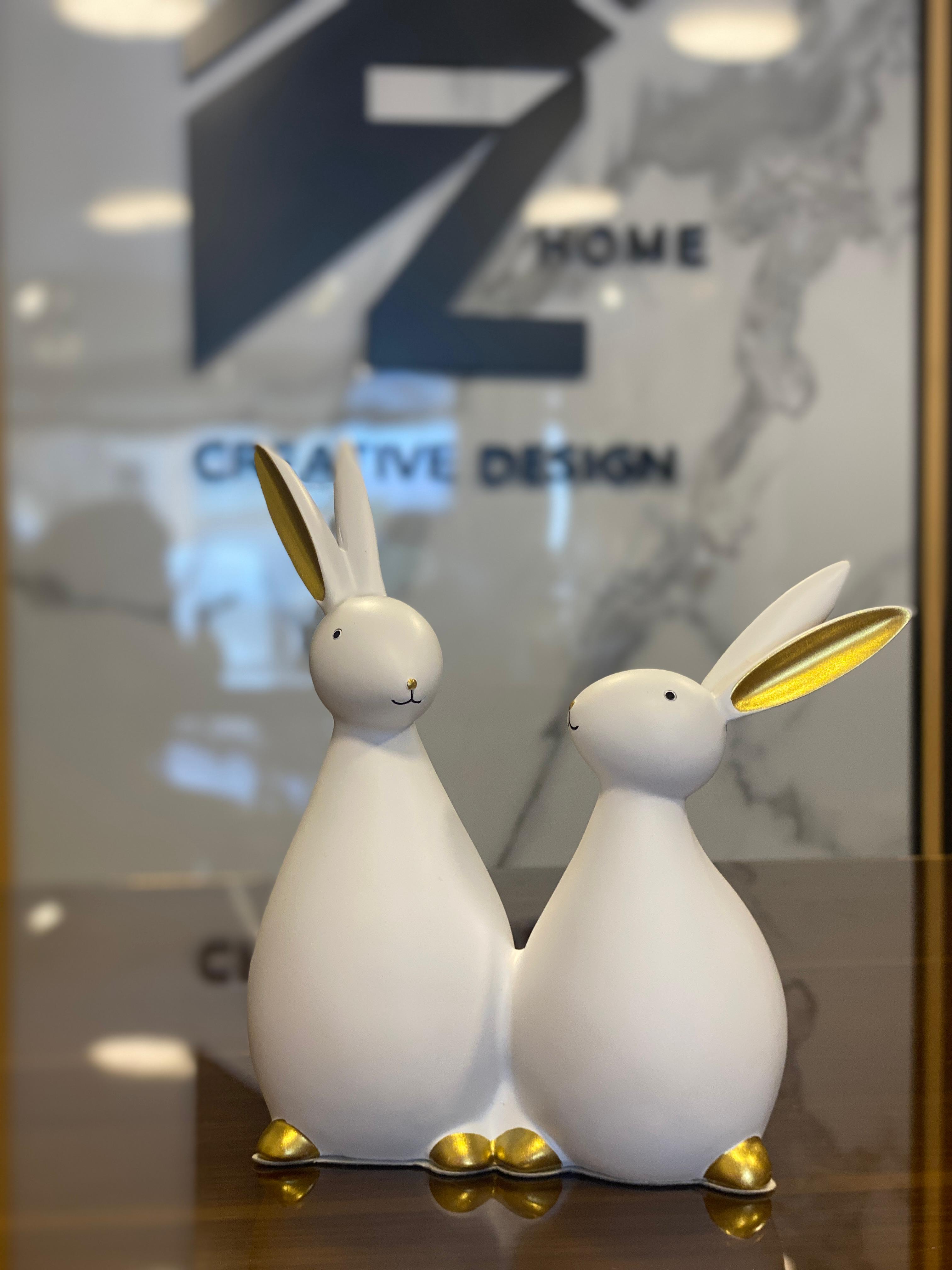A decorative pair of white bunny figurines with golden details