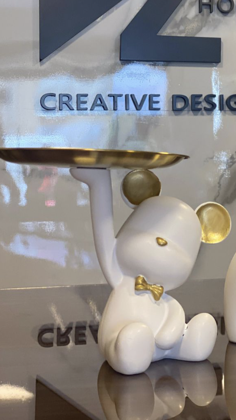 A decorative bear-shaped tray holder with golden details